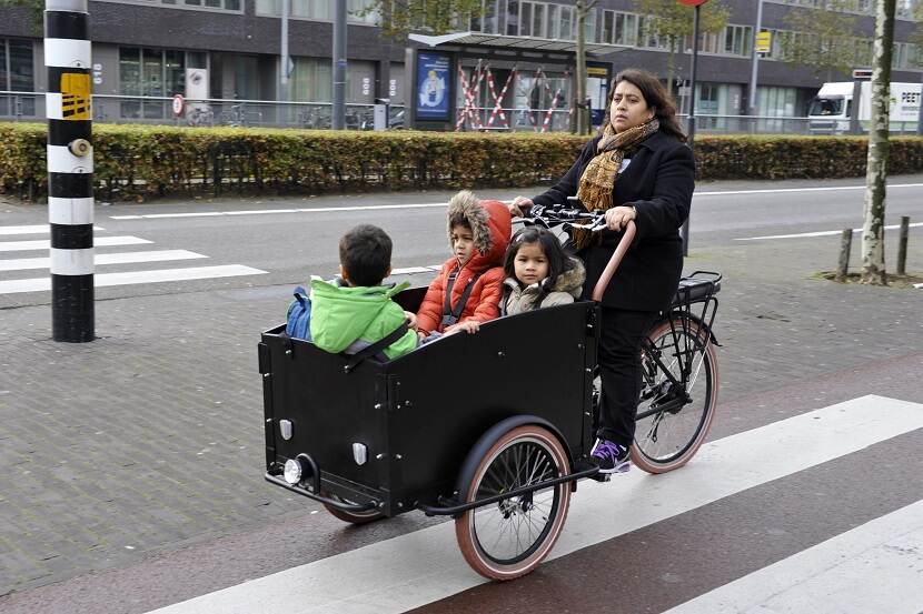 Vrouw op Vogue Troy bakfiets met kinderen in de bak