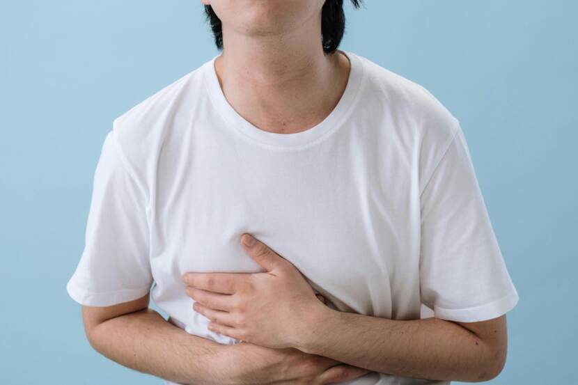 Man in wit t-shirt met buikpijn